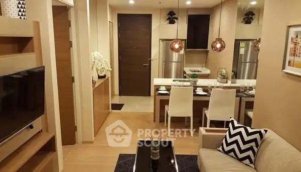 Modern open-plan living room and kitchen with stylish decor and pendant lighting.