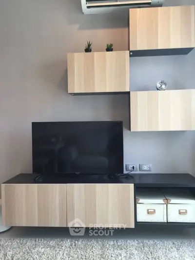 Modern living room with sleek wooden cabinets and flat-screen TV