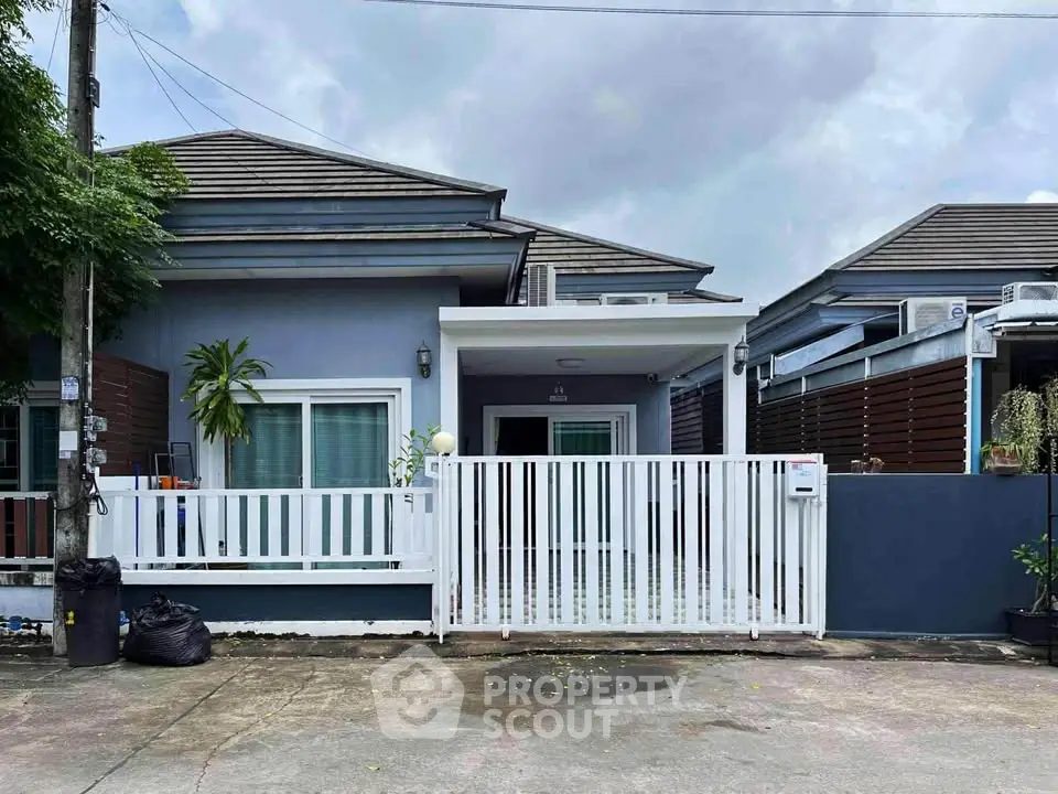 Charming single-story house with modern design and white fence in a quiet neighborhood.