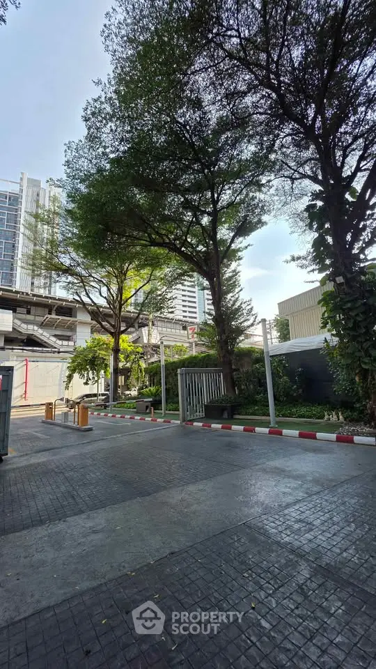Modern urban building entrance with lush greenery and paved walkway