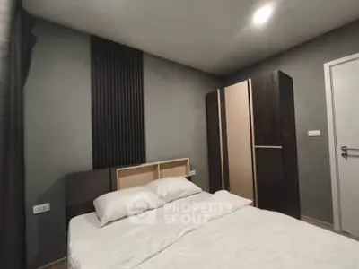 Modern bedroom with minimalist design featuring a cozy bed and sleek wardrobe.