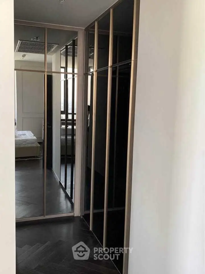 Sleek modern hallway with mirrored closet doors and elegant flooring.