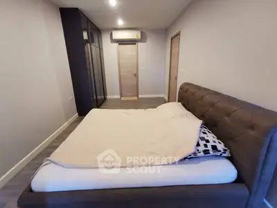 Spacious modern bedroom with stylish bed and ample closet space.