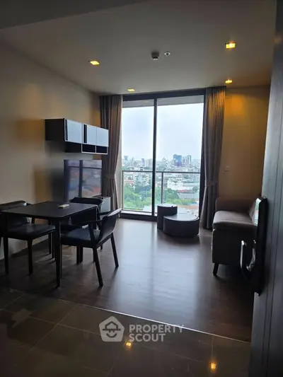 Modern living room with city view, featuring sleek furniture and floor-to-ceiling windows.