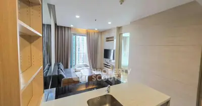 Modern open-layout living room with sleek kitchen and cozy seating area