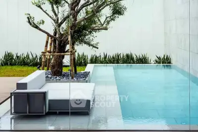 Luxurious modern poolside with sleek design and lush greenery, perfect for relaxation and entertainment.