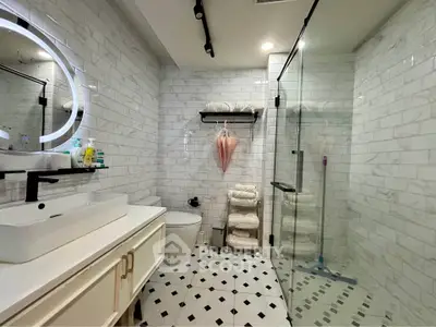 Modern bathroom with glass shower and stylish vanity in luxury home
