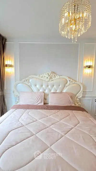 Luxurious bedroom with elegant chandelier and ornate headboard, perfect for sophisticated living.