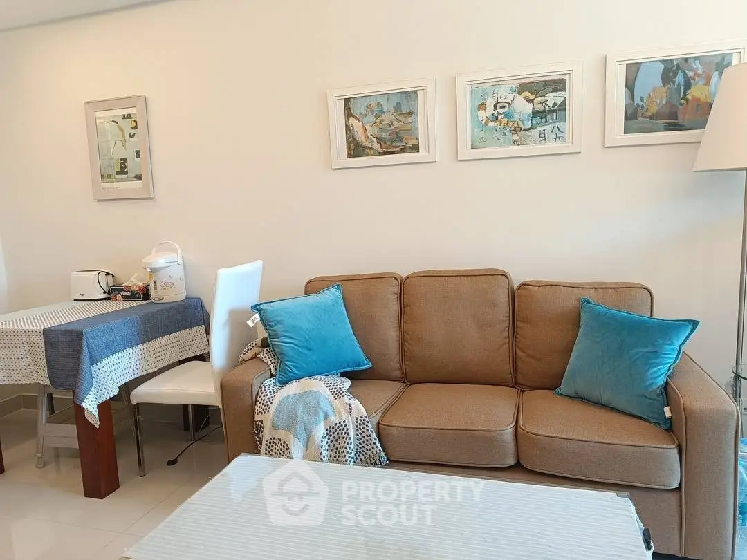 Cozy living room with brown sofa, blue cushions, and modern decor.