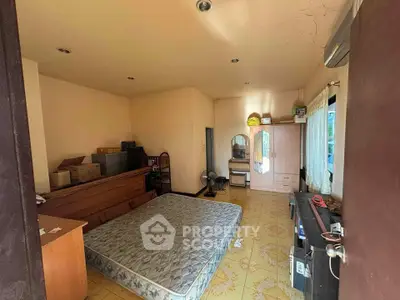 Spacious bedroom with natural light, featuring a large window and ample storage space.