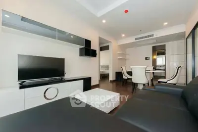 Modern living room with sleek furniture and open dining area, perfect for contemporary living.