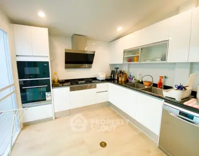 Modern kitchen with sleek white cabinets and stainless steel appliances