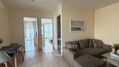 Spacious living room with modern decor and natural light in a stylish apartment.