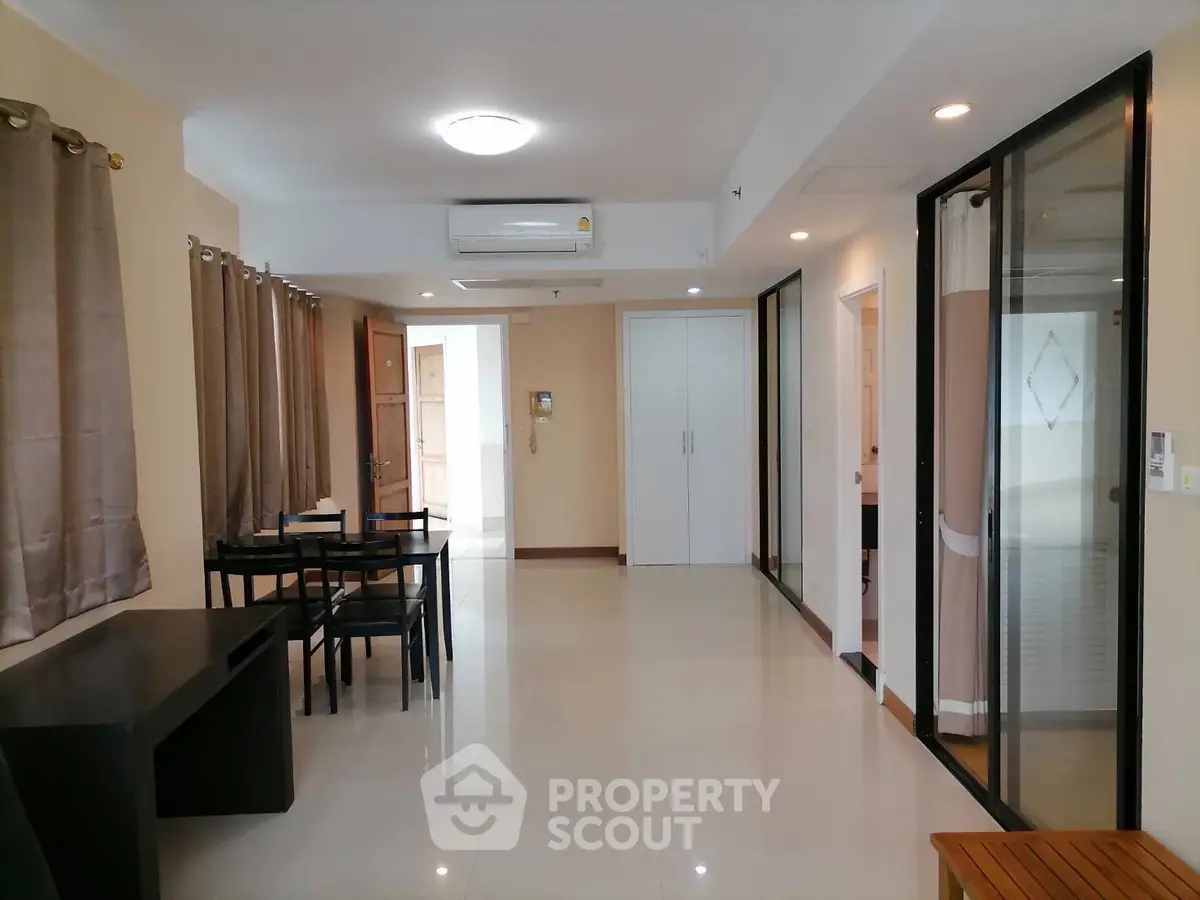Spacious modern living room with dining area and large windows in a stylish apartment.