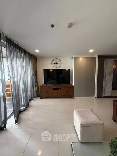 Spacious living room with modern decor and large windows for natural light.