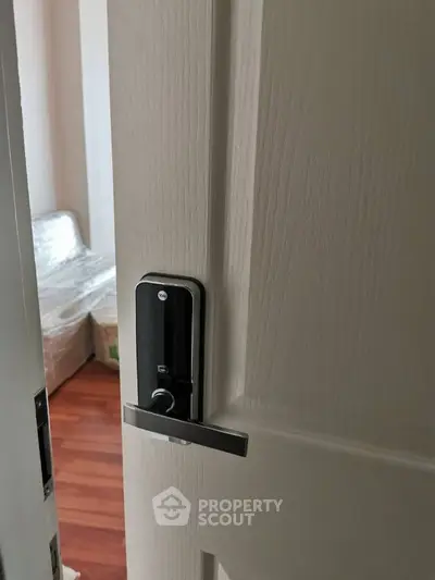 Modern bedroom with sleek door handle and hardwood floors