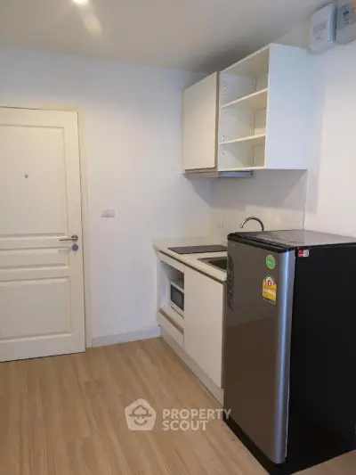 Modern compact kitchen with sleek appliances and wooden flooring