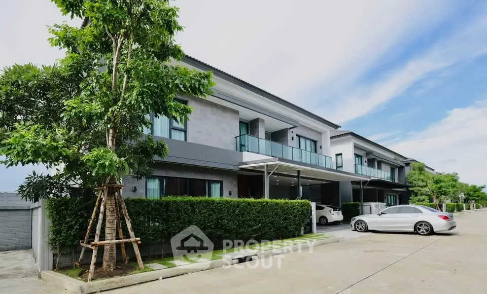 Modern townhouse with spacious driveway and lush greenery, perfect for family living.