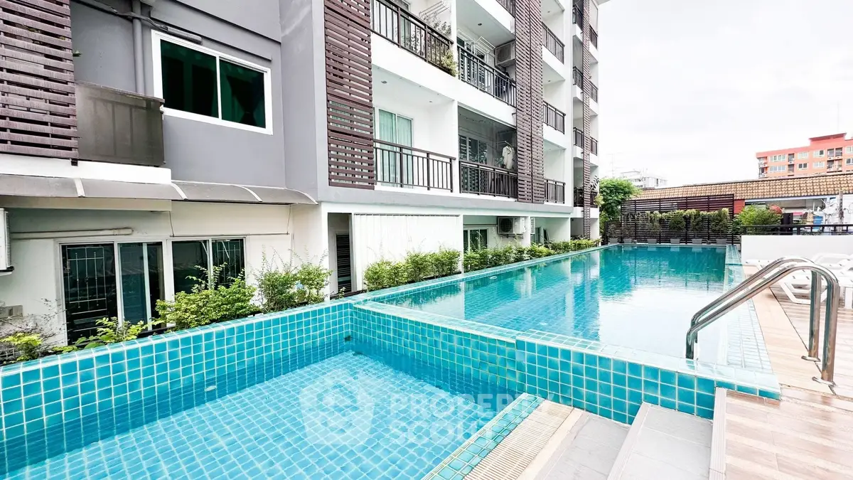 Modern apartment building with inviting outdoor pool and sleek design.
