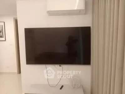 Modern living room with wall-mounted TV and air conditioning unit