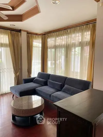 Spacious living room with elegant curtains and modern sectional sofa