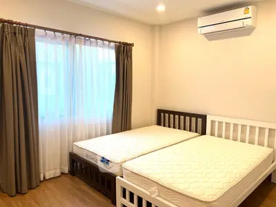Bright bedroom with twin beds and air conditioning in modern apartment