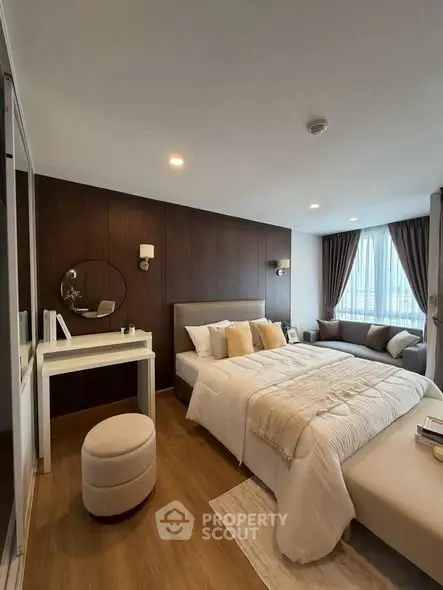 Luxurious bedroom with elegant decor and natural light, featuring a cozy bed and stylish vanity area.