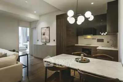 Modern open-plan kitchen and living room with elegant lighting and contemporary design.