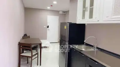 Modern compact kitchen with sleek black appliances and dining area