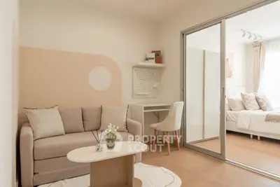 Modern living room with cozy sofa and stylish decor adjacent to a bright bedroom.