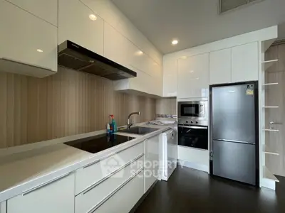 Modern kitchen with sleek white cabinets and stainless steel appliances