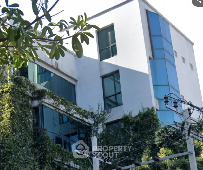 Modern building exterior with lush greenery and large windows
