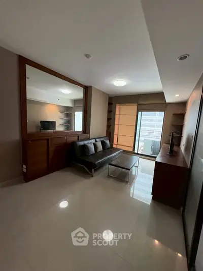 Modern living room with sleek furniture and large mirror, offering a cozy and stylish ambiance.