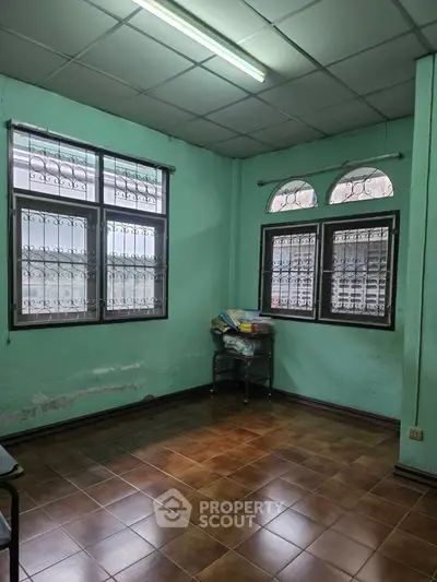 Spacious room with tiled floor and large windows, ideal for versatile use.