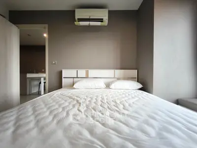 Modern bedroom with air conditioning and minimalist design, featuring a comfortable bed and neutral tones.