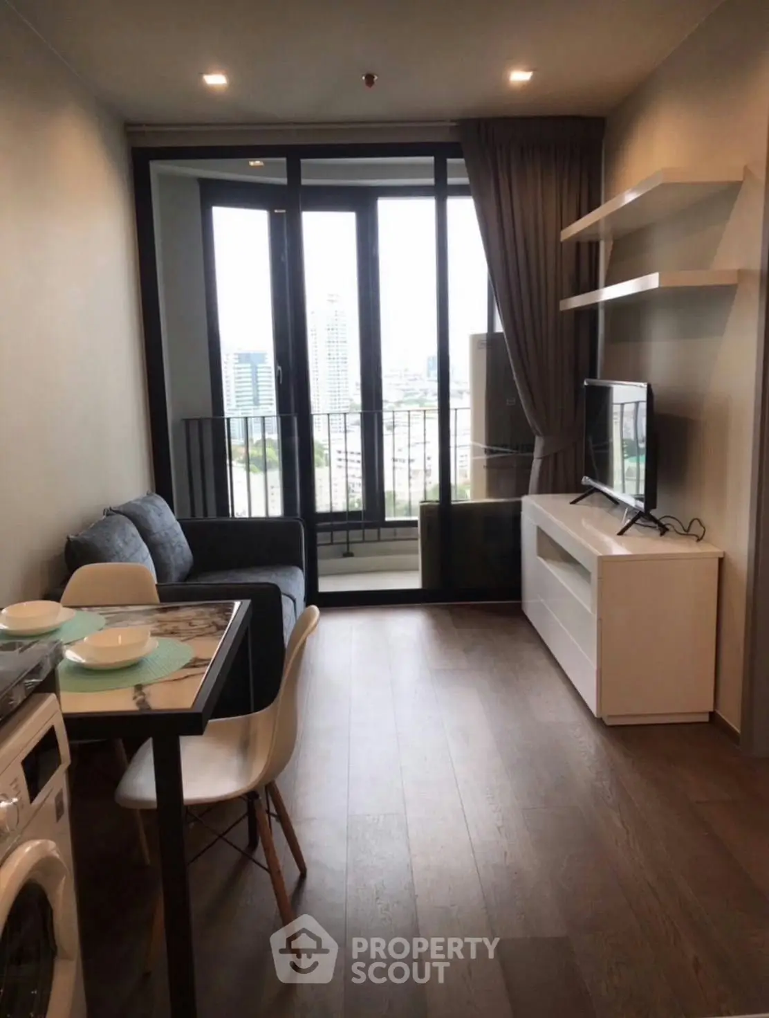 Modern living room with city view, featuring sleek furniture and open layout, perfect for urban living.