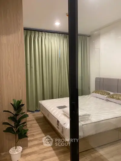 Modern bedroom with glass partition and elegant decor in a stylish apartment.