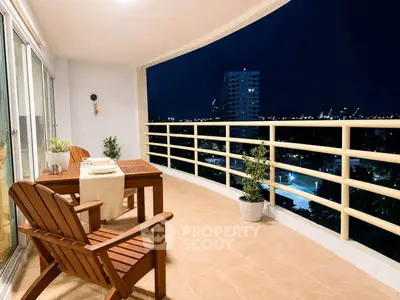Spacious balcony with night city view, perfect for relaxation and entertaining guests.