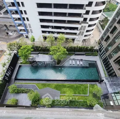Stunning aerial view of modern apartment complex with luxurious swimming pool and lush greenery.