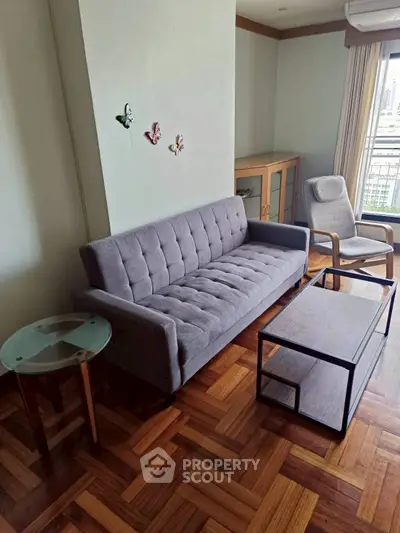 Stylish living room with parquet flooring, modern sofa, and city view window.