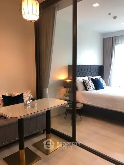 Modern bedroom with glass partition and stylish decor in a cozy apartment.