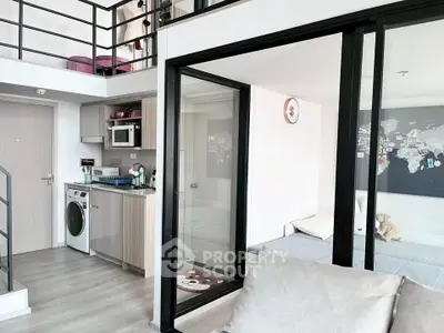 Modern loft apartment with open layout, featuring a washing machine and stylish decor.