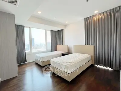 Spacious bedroom with twin beds and city view, perfect for urban living.