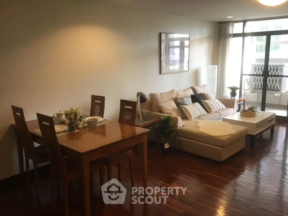 Spacious living room with elegant wooden flooring and cozy seating area, perfect for relaxation and entertaining.