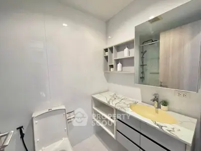 Modern bathroom with sleek design, featuring marble countertop and stylish fixtures.