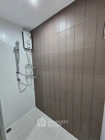 Modern bathroom with sleek shower and stylish brown accent wall tiles.