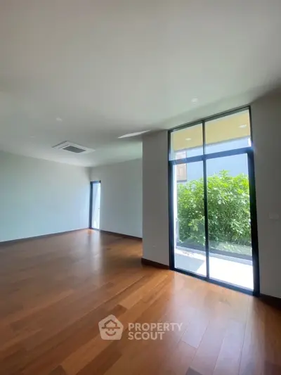 Spacious modern living room with wooden flooring and large windows