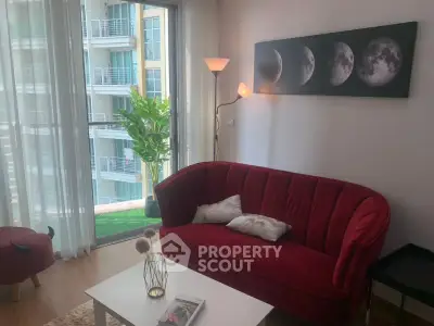 Chic living room with red velvet sofa and moon phase artwork, overlooking modern balcony view.