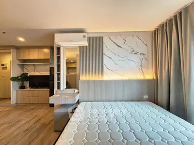 Modern bedroom with stylish decor and natural light, featuring a comfortable bed and built-in storage.