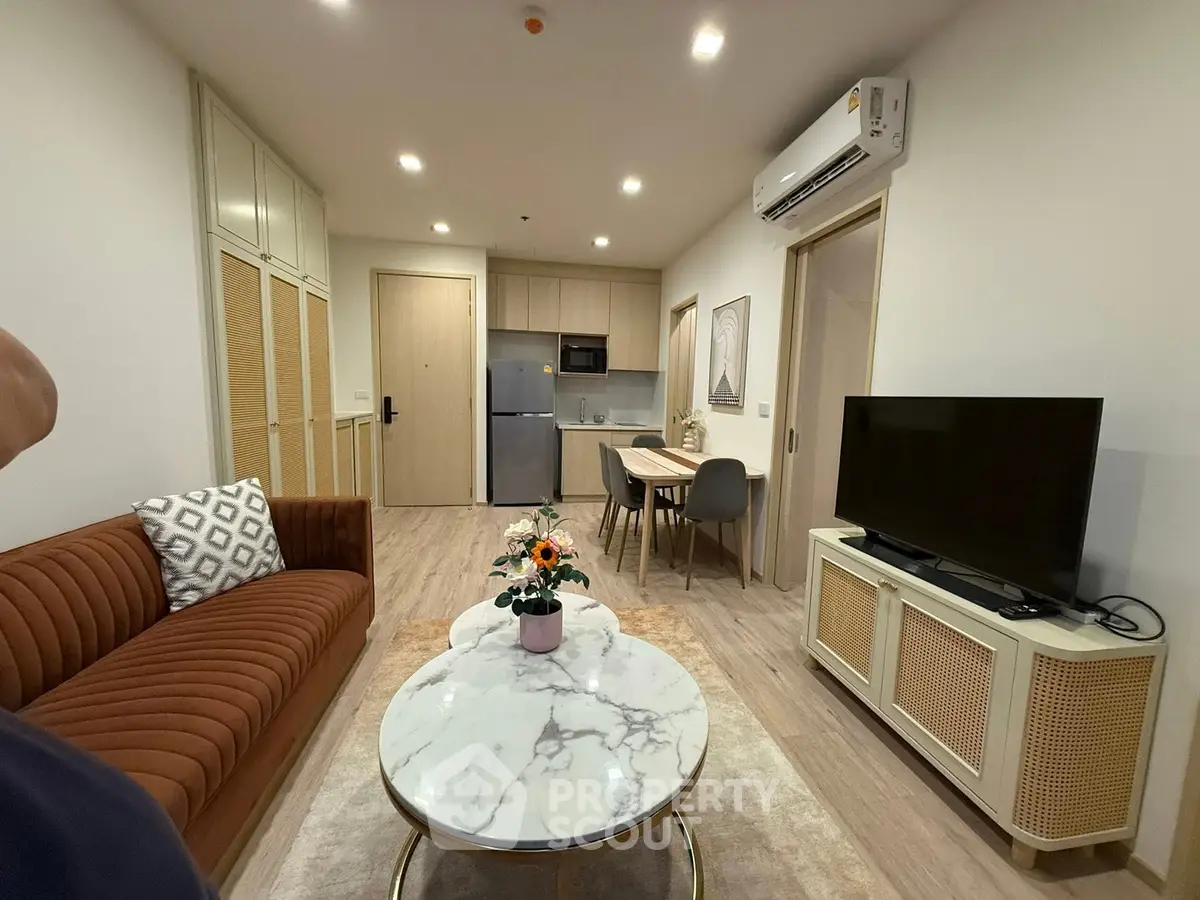 Modern living room with stylish furniture and open kitchen layout in a cozy apartment.